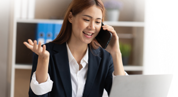 Woman talking on a phone looking at a laptop