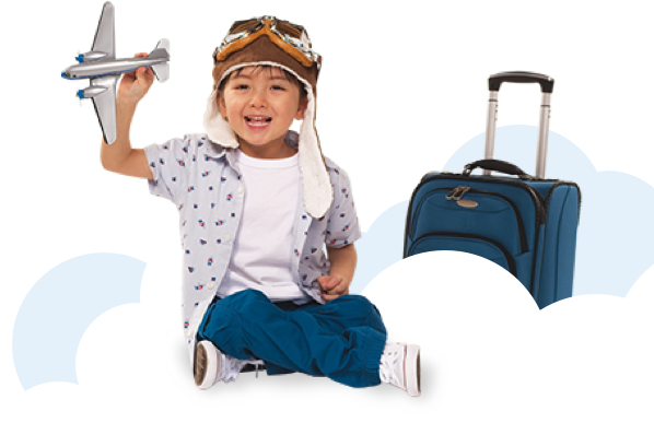 Boy sitting next to a suitcase, playing with a model airplane 